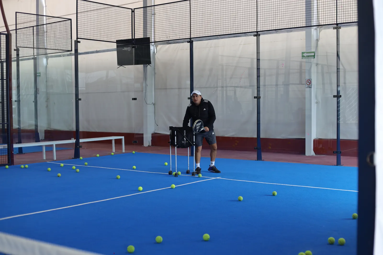 Cancha de pádel techada con pelotas de entrenamiento